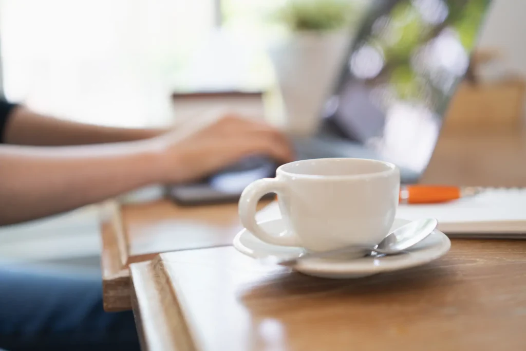 A woman sitting at a café with laptop open